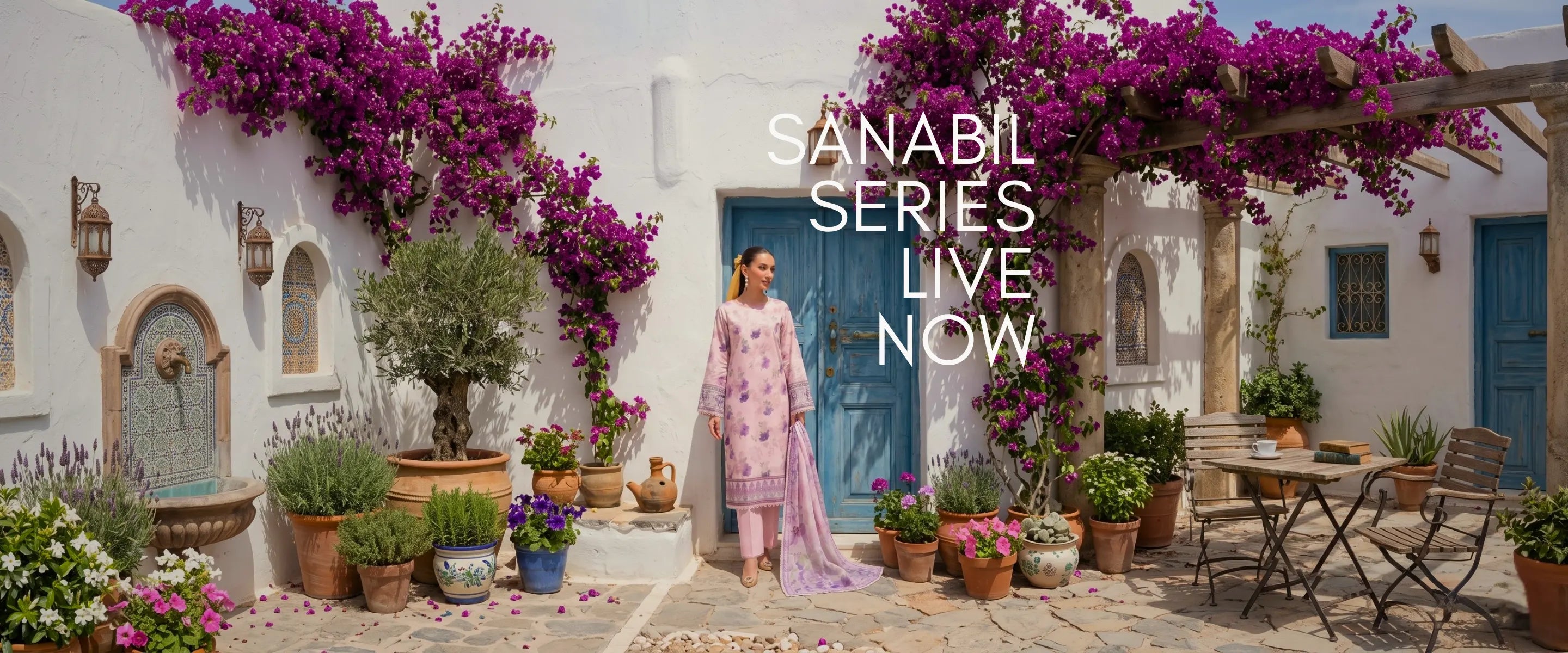 Woman in a pink dress standing in a picturesque outdoor setting with flowers and a 'Sanabil Series' text overlay.